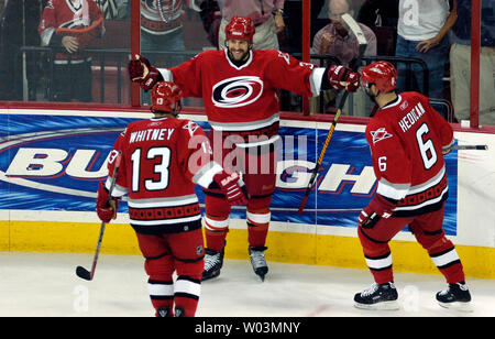 Les Hurricanes de la Caroline' Doug Weight, centre, ouvre ses bras pour fêter avec ses coéquipiers Ray Whitney, à gauche, et Bret Hedican après avoir marqué contre les Devils du New Jersey au cours du jeu 1 de la demi-finale de conférence de l'Est de la LNH au RBC Center de Raleigh, NC, le 6 mai 2006. Carolina a gagné, 6-0. (Photo d'UPI/Jeffrey A. Camarati) Banque D'Images