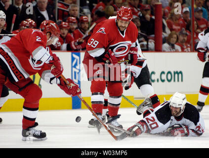 Devils du New Jersey' Jay Pandolfo, droite, atteint pour la rondelle entre les Hurricanes de la Caroline' Glen Wesley, à gauche, et Doug Weight pendant la partie 2 de la demi-finale de conférence de l'Est de la LNH au RBC Center de Raleigh, NC, le 6 mai 2006. (Photo d'UPI/Jeffrey A. Camarati) Banque D'Images