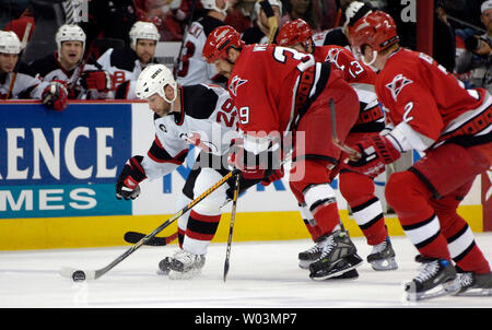 New Jersey Devils' Grant Marshall, gauche, poursuit le puck devant les Hurricanes de la Caroline Doug Weight, Ray Whitney, dos, et Glen Wesley, droite, au cours du jeu 2 de la demi-finale de conférence de l'Est de la LNH au RBC Center de Raleigh, NC, le 6 mai 2006. (Photo d'UPI/Jeffrey A. Camarati) Banque D'Images