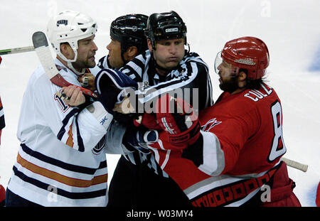 Edmonton Oilers' Ethan Moreau, gauche, son séparé de Carolina Hurricanes' Matt Cullen, droite, par juges Jay Sharrers, centre gauche, et Greg Devorski pendant le jeu 2 de la finale de la Coupe Stanley de la LNH au RBC Center de Raleigh, NC, le 7 juin 2006. Carolina a gagné 5-0 à prendre un plomb de 2-0 dans la série. (Photo d'UPI/Jeffrey A. Camarati) Banque D'Images