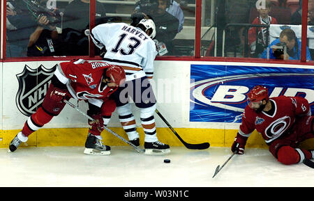 Edmonton Oilers' Todd Harvey, centre, tente de contrôler la rondelle entre les Hurricanes de la Caroline' Rod Brind'Amour, gauche, et Bret Hedican au cours de Match 7 de la finale de la Coupe Stanley de la LNH au RBC Center de Raleigh, NC Le 19 juin 2006. Carolina a gagné 3-1 pour saisir la première Coupe Stanley. (Photo d'UPI/Jeffrey A. Camarati) Banque D'Images