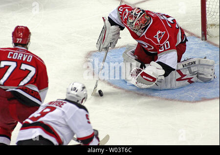 Les Hurricanes de la Caroline' Cam Ward (30) contrôle la rondelle devant son coéquipier Joe Corvo (77) et New Jersey Devils' Zach Parise (9) au cours de la deuxième période d'un match de hockey dans la région de Raleigh, Caroline du Nord le 6 janvier 2009. Les Hurricanes ont remporté 3-2. (Photo d'UPI/Karl DeBlaker) Banque D'Images