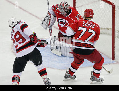 New Jersey Devils' Johnny Oduya (29) a son tir bloqué par le gardien Cam Ward des Hurricanes de la Caroline (30) avec les ouragans Joe Corvo (77) à proximité au cours de la deuxième période de la Conférence de l'Est de la LNH Coupe match de hockey à Raleigh (Caroline du Nord), le 21 avril 2009. Les ouragans a gagné 4-3 à lier la série à 2 jeux chacune. (Photo d'UPI/Jeff Basladynski) Banque D'Images