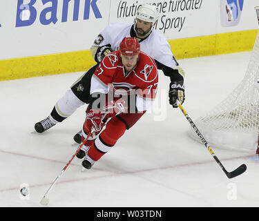 Les Hurricanes de la Caroline Joe Corvo (77) porte la rondelle dans la zone défensive contre les Penguins de Pittsburgh Bill Guerin (haut)au cours de la troisième période de jeu 3 d'une finale de conférence de l'Est de la LNH match de hockey à Raleigh (Caroline du Nord), le 23 mai 2009. Les pingouins battre les Hurricanes 6-2. (Photo d'UPI/Jeff Basladynski) Banque D'Images