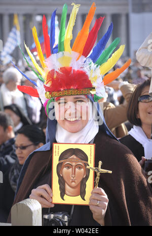 Une religieuse portant un Indien headress détient un tableau représentant Kateri Tekakwitha, Place Saint-Pierre, dans la cité du Vatican le 21 octobre 2012. Le pape Benoît XVI a nommé sept nouveaux saints aujourd'hui, Kateri Tekakwitha du NOUS, Jacques Berthieu de France, Maria Anna Cope de l'Allemagne, Pedro Calungsod des Philippines, Maria Schaffer d'Allemagne, Giovanni Battista Piamarta de l'Italie, Maria del Carmen de l'Espagne, place Saint Pierre au Vatican. UPI/Stefano Spaziani Banque D'Images