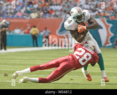 Le receveur des Dolphins de Miami Chris Chambers (84) est abordé par Arizona Cardinals Duane Starks (28) le 7 novembre 2004 au Pro Player Stadium à Miami, FL. Les Arizona Cardinals battre les dauphins de Miami 24-23. (Photo d'UPI/Robert Stolpe) Banque D'Images