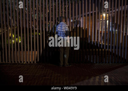 Un homme regarde à travers la clôture à la maison Mandela, l'ancienne maison de Nelson Mandela, après qu'il a été libéré de l'île Robben, à Soweto, Afrique du Sud, le 29 juin 2013. L'ancien Président sud-africain a été hospitalisé pendant 22 jours maintenant et est toujours dans un état critique. UPI/Charlie Shoemaker Banque D'Images