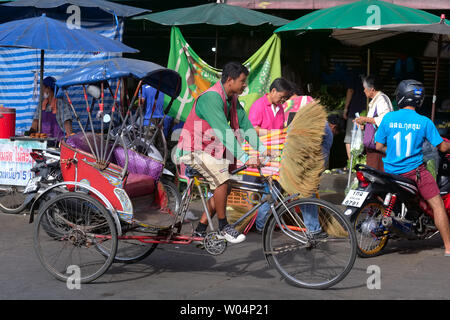 Un chauffeur avec un des quelques samlor ou trois roues vélos-pousse en Thaïlande, dans un marché à Nonthaburi près de Bangkok Banque D'Images