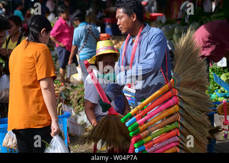 Un migrant du Myanmar dans un marché à Nonthaburi, près de Bangkok, Thaïlande, peu coûteux de vente manches faits de brindilles Banque D'Images