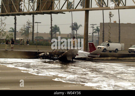 San Diego fireman inspecte les petits Piper avion haute performance qui s'est écrasé au décollage de l'aéroport de San Diego Montgomery avec un seul pilote à bord. Pilot s'éloigna sans blessure majeure. San Diego les feux se propagent de Ramona au sud-ouest d'entrer dans les limites de la ville de San Diego consommant environ 100 000 acres, brûlant 260 bâtiments, laissant 3 morts, 800 avec les pompiers qui travaillent plusieurs feux à date. (UPI/Tom Theobald) Banque D'Images