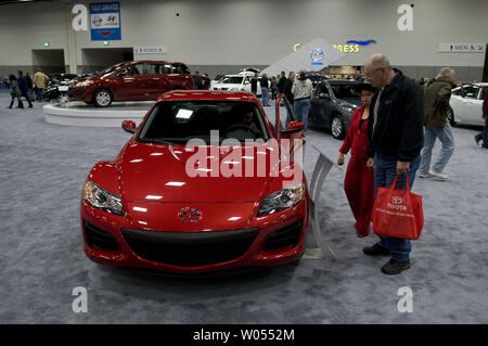 Les visiteurs du salon de l'Automobile International de San Diego à regarder par dessus un nouveau 2011Mazda RX8, ainsi que certaines des plus de 400 véhicules de modèle 2011 à l'affiche au centre de congrès de San Diego, le 30 décembre 2010 .La auto show devrait attirer plus de trois cent mille personnes et est les six plus grandes dans le pays, mettant en valeur les concept cars et les nouvelles versions du haut d'automobiles. ( UPI Photo/Earl S. Cryer) Banque D'Images