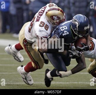 Seattle Seahawks' wide receiver Bobby Engramme , centre, est descendu par San Francisco 49ers' Julian Peterson (98) et de sécurité solide Ben Emanuel au premier trimestre à Seattle le 11 décembre 2005. Engramme pris six passes pour 65 verges et marqué deux touchés dans les Seahawks 41-3 victoire contre les 49ers. (Photo d'UPI/Jim Bryant) Banque D'Images