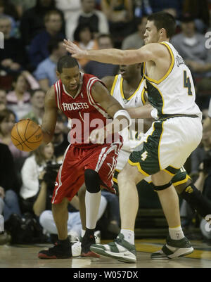 Les Houston Rockets Tracy McGrady, gauche, est maintenu à partir du panier par les Seattle Supersonics' Nick Collison (4) et Damien Wilkins (12) au deuxième trimestre au Key Arena de Seattle le 15 décembre 2005.(UPI Photo/Jim Bryant) Banque D'Images