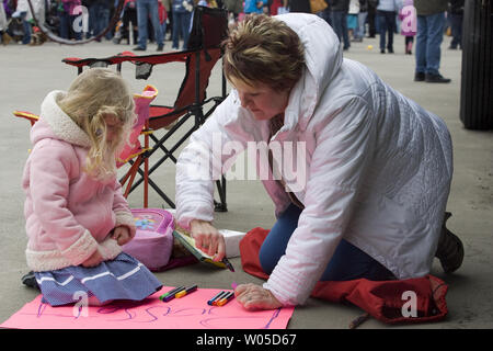 Trois ans Savannah aide sa mère Christina Bassett dessiner un signe de bienvenue pour le maître de Brian Bassett comme l'USS John C. Stennis, un 1 092 mètres de long porte-avion tire dans son port d'attache le 2 mars, 2012, à la Station Navale de Kitsap Bremerton, Washington. Le transporteur et c'est 3 200 membres de l'équipage est arrivé vendredi après un déploiement de six mois à l'appui des opérations au Moyen Orient. UPI /Jim Bryant Banque D'Images