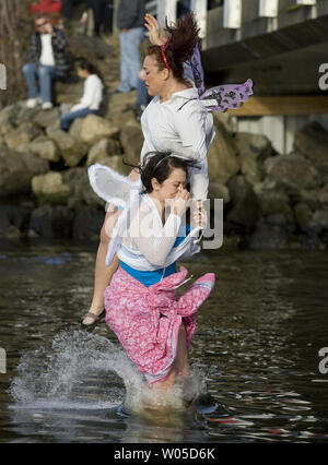 Tania Hernandez tient son nez et la main de Stephanie comme Vasatka ils ont frappé l'eau après le saut dans le 28e congrès annuel de l'ours polaire sauter dans la lagune en Burley Olalla, Washington le 1 janvier 2012. Plus de 500 participants ont bravé le froid hardy eaux du lagon à se joindre à l'assemblée le jour de l'an la tradition. UPI /Jim Bryant Banque D'Images