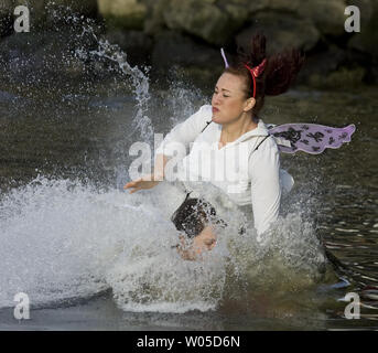 Tania Hernandez, avant, et Stephanie Vasatka touché l'eau après le saut dans le 28e congrès annuel de l'ours polaire sauter dans la lagune en Burley Olalla, Washington le 1 janvier 2012. Plus de 500 participants ont bravé le froid hardy eaux du lagon à se joindre à l'assemblée le jour de l'an la tradition. UPI /Jim Bryant Banque D'Images