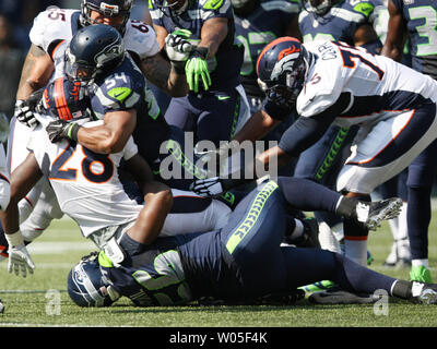 Seattle Seahawks linebacker Bobby Wagner (54) et défensive fin avril Falaise (56) stop running back Denver Broncos montée bille (28) pour une perte de cour au deuxième trimestre à CenturyLink Field à Seattle, Washington le 21 septembre 2014. Les Seahawks a gagné 26-20 en prolongation. UPI/Jim Bryant Banque D'Images