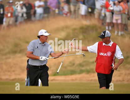 Phil Mickelson clubs échanges avec caddie Jim Mackay sur le deuxième trou du premier tour de l'US Open Championship 115e à Chambers Bay le 18 juin 2015 à University Place, Washington. Photo par Kevin Dietsch/UPI Banque D'Images