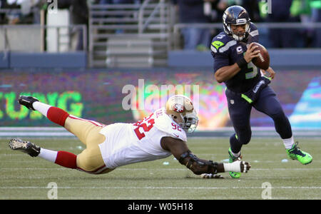 Seattle Seahawks quarterback Russell Wilson (3) brouille loin de San Francisco 49ers attaquer défensive Cadran Quinton (92) au champ CenturyLink à Seattle, Washington le 22 novembre 2015. Les Seahawks battre les 49ers 29-13. Photo par Jim Bryant/UPI Banque D'Images