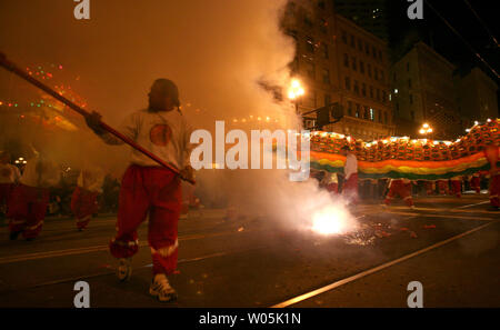 Les membres d'une équipe de dragon tout en préformes de pétards explosent sur Market Street San Francisco pendant le festival du Nouvel An chinois et défilé dans les rues du centre-ville de San Francisco le 3 mars 2007. (Photo d'UPI/Aaron Kehoe) Banque D'Images