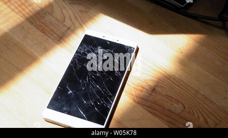 Xiaomi MI Max Smartphone avec écran cassé matrix se trouve sur table en bois. La lumière du soleil met l'concequences de chute accident Kiev, Ukraine, le 5 Ju Banque D'Images