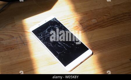 Xiaomi MI Max Smartphone avec écran cassé matrix se trouve sur table en bois. La lumière du soleil met l'concequences de chute accident Kiev, Ukraine, le 5 Ju Banque D'Images