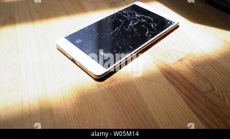 Xiaomi MI Max Smartphone avec écran cassé matrix se trouve sur table en bois. La lumière du soleil met l'concequences de chute accident Kiev, Ukraine, le 5 Ju Banque D'Images