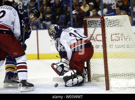 Columbus Blue Jackets gardien Marc Denis est tout simplement l'enregistrer sur un tir de Saint Louis Blues Kieth Tkachuk Blue Jackets tandis que Luke Richardson des liens jusqu'en troisième période au Savvis Center à St Louis le 13 mars 2004. (PHoto d'UPI/Bill Greenblatt Banque D'Images