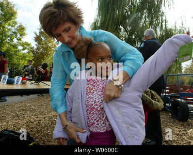 Brenda Warner, épouse de New York Giants quarterback Kurt Warner, aide peu de cinq ans Allamby ciel avec sa nouvelle veste à la pierre angulaire du Centre pour l'apprentissage, au cours de l'annonce de la Warner Warm-Up Coat Drive, à St Louis Le 29 octobre 2004. Warner, qui a lancé le programme alors que son mari a joué pour les St Louis Rams, va maintenant demander l'aide du Service de police de Saint Louis pour aider à recueillir les 15 000 nouveau ou utilisé des manteaux d'hiver pour les nécessiteux. Warner exploite le 'First Things First' Foundation. (Photo d'UPI/Bill Greenblatt) Banque D'Images