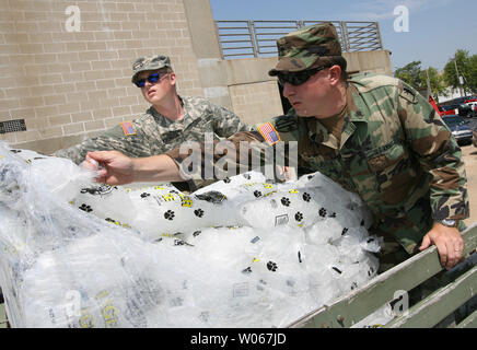 Les membres de la Garde nationale du Missouri charger un camion avec de la glace qu'ils distribueront à St Louis le 25 juillet 2006. La Garde côtière canadienne, a présenté pour aider les efforts de rétablissement de puissantes tempêtes le 19 juillet et 21, restent à St Louis pour distribuer la glace et l'eau que les températures commencent à ramper en arrière jusqu'au milieu des années 90. (Photo d'UPI/Bill Greenblatt) Banque D'Images