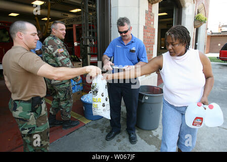 Les membres de la Garde nationale du Missouri et de l'eau glace passer dehors à Debra White Fire Department à St Louis Maison moteur 28 à St Louis le 25 juillet 2006. La Garde côtière canadienne, a présenté pour aider les efforts de rétablissement de puissantes tempêtes le 19 juillet et 21, restent à St Louis pour distribuer la glace et l'eau que les températures commencent à ramper en arrière jusqu'au milieu des années 90. (Photo d'UPI/Bill Greenblatt) Banque D'Images