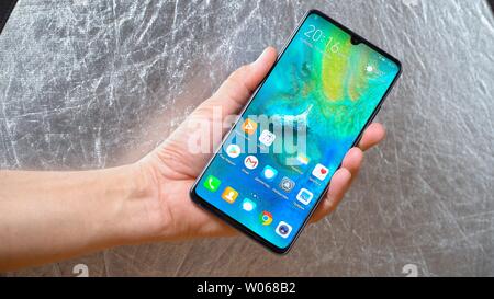 Man holding smartphone Huawei Mate 20 X dans une main sur fond gris brillant. L'affichage est allumé et le menu principal est vu Kiev, Ukraine 15 Juin Banque D'Images