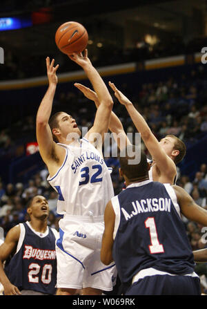 Saint Louis University Billikens Luc Meyer (32) pousses pour deux à la défense de ducs Duquesne Phillip Fayne (20) Scott Grote et Aaron Jackson (1) au cours de la première moitié du Scottrade Center à St Louis le 6 janvier 2007. (Photo d'UPI/Bill Greenblatt) Banque D'Images