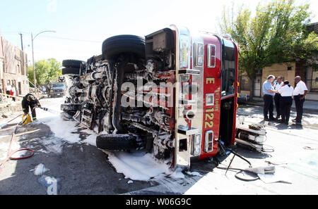 Un pompier St Louis sprays mousse sur la face inférieure d'un camion à incendie qui a participé avec un autre véhicule de pompiers, tant sur le chemin de la même incendie en Amérique du Saint Louis le 10 octobre 2008. Un total de huit pompiers ont été transportés à l'hôpital. L'un pumper était fliped sur le côté tandis qu'un autre s'est heurtée à une voiture en stationnement. (Photo d'UPI/Bill Greenblatt) Banque D'Images