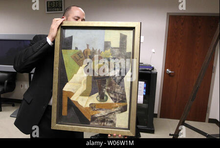 Agent Spécial du FBI Tim Carpenter du bureau de Miami comporte un tableau volé retrouvé dans une salle avant une conférence de presse à St Louis le 20 octobre 2010. Le tableau a été volé à l'accueil de Clifton Hyatt il y a plus de six ans. La peinture à l'huile 1926 par Juan Gris, a été prise le 18 avril 2004 et retrouvé en Floride. Robert C. Dibartolo de Fort Pierce, en Floride, a été arrêté après avoir montré un employé du FBI sous couverture photos de la peinture. Dibartolo, 68 ans, a plaidé coupable en cour fédérale en juillet en Floride pour la vente ou de la réception de biens volés et a été condamné le 20 septembre à un an et d'o Banque D'Images