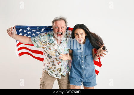 Célébration d'un jour de l'indépendance. Stars and Stripes. Man avec le drapeau des États-Unis d'Amérique isolated on white background studio. L'air fou heureux et fier qu'un patriote de son pays. Banque D'Images