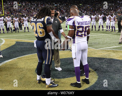 Saint Louis Rams Daryl Richardson (26) et du Minnesota Vikings Antoine Winfield (26) tenir la main avec leurs entraîneurs, Jeff Fisher (L) et Leslie Frazier comme une minute de silence est observée pour les 26 victimes qui ont été tués dans l'école secondaire de New York avant de leur jeu à l'Edward Jones Dome à St Louis le 16 décembre 2012. UPI/Bill Greenblatt Banque D'Images