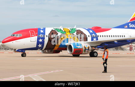 Un travailleur rampe dirige le nouveau 'Missouri Southwest Airlines, un Boeing 737-700', comme il les taxis à Lambert-St. Louis International Airport à St Louis le 15 avril 2015. Célébrant plus de 30 années de service dans l'état du Missouri Southwest Airlines dévoile ses nouveaux aéronefs spécialisés, une représentation de haut vol du drapeau de l'état du Missouri, mettent en exergue le grand sceau du Missouri. L'avion s'envolera vers 94 destinations dans 41 pays et six pays voisins. L'avion a fait escale à Kansas City et Saint Louis. Photo de Bill Greenblatt/UPI Banque D'Images
