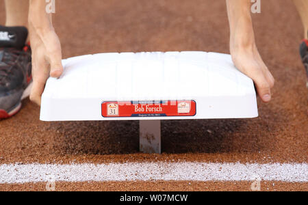 Un membre d'équipage Stade Busch installe une base avec le nom de Bob Forsch sur elle, avant un match entre les Marlins de Miami et les Cardinals de Saint-Louis au Busch Stadium de Saint-Louis le 14 août 2015. Forsch, décédé en 2011, est un ancien lanceur avec les Cardinaux, et est l'un des quatre anciens joueurs et entraîneurs qui sera intronisée dans les Hall of Fame Le 15 août 2015. Photo de Bill Greenblatt/UPI Banque D'Images