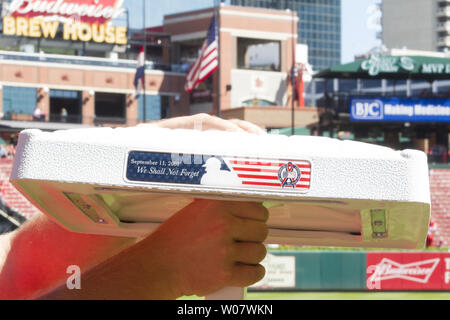 Comme le drapeau américain vagues à mi-mât, un gardien du Stade Busch s'apprête à installer des bases spéciales pour le Brewers-St Milwaukee. Louis Cardinals baseball jeu à St Louis le 11 septembre 2016, marquant le 15 e anniversaire de l'terriost les attaques. Photo de Bill Greenblatt/UPI Banque D'Images