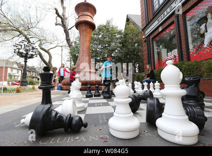 Les enfants jouent sur un grand jeu d'échecs à côté de la plus grande pièce d'échecs à l'extérieur du monde d'Échecs Hall of Fame and Museum à St Louis le 13 avril 2018. Le king chess piece certifié par Guinness World Records, les peuplements de 20 pieds de haut avec une base de 9 pieds, 2 pouces, et est une échelle exacte réplique de la pièce King Staunton noir utilisé dans la première tasse Sinquefield tenue au Club d'échecs de Saint Louis par an depuis 2013. Photo de Bill Greenblatt/UPI Banque D'Images