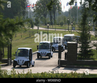 Le président russe Vladimir Poutine conduit une voiture électrique (2L), comme il arrive avec sa femme Lyudmila à un dîner avec le président américain George W. Bush dans le Guest House en italien la maison complexe de Palais à Strelna, dans la banlieue de Saint-Pétersbourg le 14 juillet 2006. Bush est en visite en Russie pour assister au sommet du G8 cette semaine. (Photo d'UPI/Anatoli Zhdanov) Banque D'Images