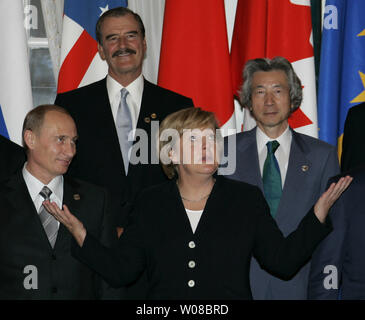 La chancelière allemande Angela Merkel (2e R) réagit comme le président russe Vladimir Poutine (G), le président mexicain Vicente Fox (2L) et le Premier ministre japonais Junichiro Koizumi sourire lors d'une photo de groupe des dirigeants du G8 à la suite de la session finale du Sommet du G8 à Saint-Pétersbourg, Russie le 17 juillet 2006. (Photo d'UPI/Anatoli Zhdanov) Banque D'Images