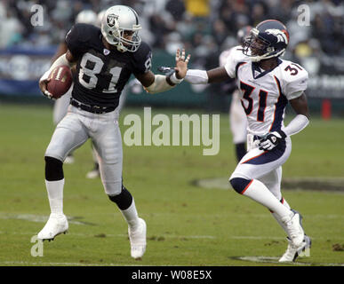 Oakland Raiders WR Tim Brown (81) tente de repousser les Denver Broncos Kelly Herndon après avoir attrapé un col Rick Mirer à Oakland, CA, le 30 novembre 2003 . Les raiders Broncos défait le 22 août 2006. (Photo d'UPI/Terry Schmitt) Banque D'Images