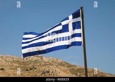 Le drapeau national grec sur le front de mer de Lidivia sur l'île grecque de Tilos. Banque D'Images