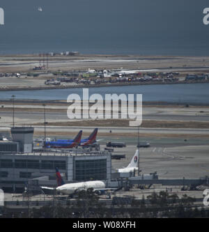 Les véhicules d'urgence entourent les vestiges d'un Boeing 777 d'Air Asiana sur la piste de l'Aéroport International de San Francisco (arrière-plan) après qu'il s'est écrasé à l'atterrissage à San Francisco le 6 juillet 2013. L'avion était en provenance de Séoul. UPI/Terry Schmitt Banque D'Images
