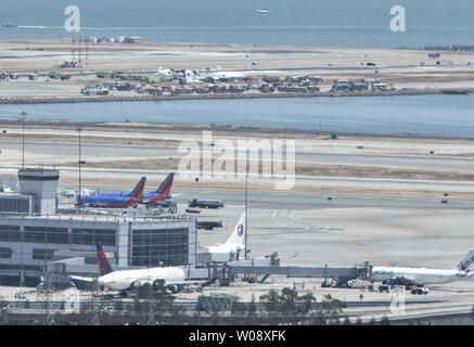 Les véhicules d'urgence entourent les vestiges d'un Boeing 777 d'Air Asiana (arrière-plan) sur la piste de l'Aéroport International de San Francisco après qu'il s'est écrasé à l'atterrissage à San Francisco le 6 juillet 2013. L'avion était en provenance de Séoul. UPI/Terry Schmitt Banque D'Images