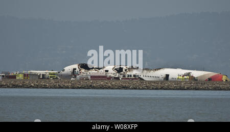 Les véhicules d'urgence entourent les vestiges d'un Boeing 777 d'Air Asiana sur la piste de l'Aéroport International de San Francisco après qu'il s'est écrasé à l'atterrissage à San Francisco le 6 juillet 2013. L'avion était en provenance de Séoul. UPI/Terry Schmitt Banque D'Images