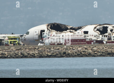 Les véhicules d'urgence entourent les vestiges d'un Boeing 777 d'Air Asiana sur la piste de l'Aéroport International de San Francisco après qu'il s'est écrasé à l'atterrissage à San Francisco le 6 juillet 2013. L'avion était en provenance de Séoul. UPI/Terry Schmitt Banque D'Images