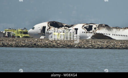 Les véhicules d'urgence entourent les vestiges d'un Boeing 777 d'Air Asiana sur la piste de l'Aéroport International de San Francisco après qu'il s'est écrasé à l'atterrissage à San Francisco le 6 juillet 2013. L'avion était en provenance de Séoul. UPI/Terry Schmitt Banque D'Images